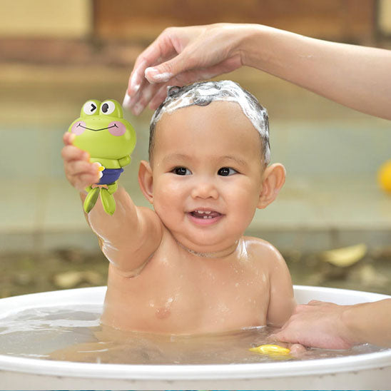 bébé prend bain joue jouet de bain grenouille verte