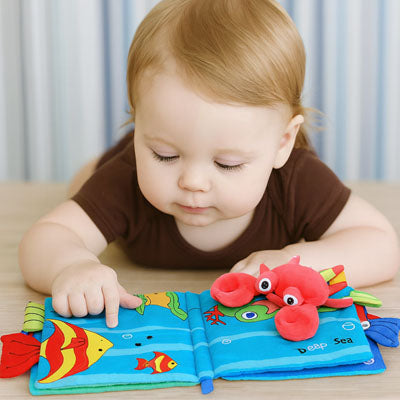 tout-petit regarde livre bebe avec poissons