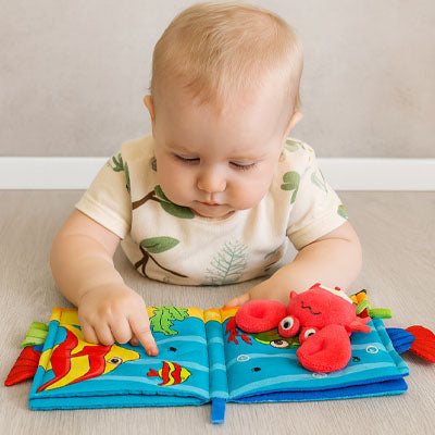nourrisson admire livre bebe avec animaux marins