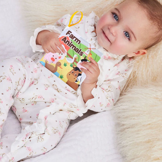 nourrisson tient livre bebe en tissus animaux ferme