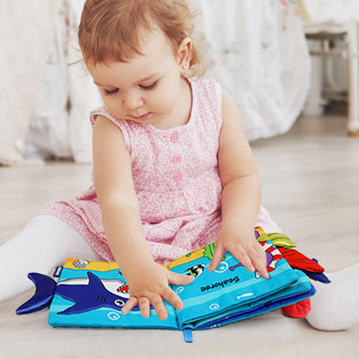 petite fille admire livre bebe animaux marins