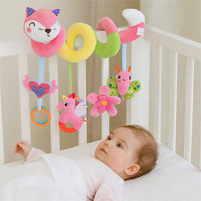 petite fille allongé lit admire spirale d'activité bébé