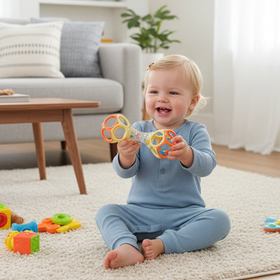 petite fille tient hochet pour bebe jaune orange